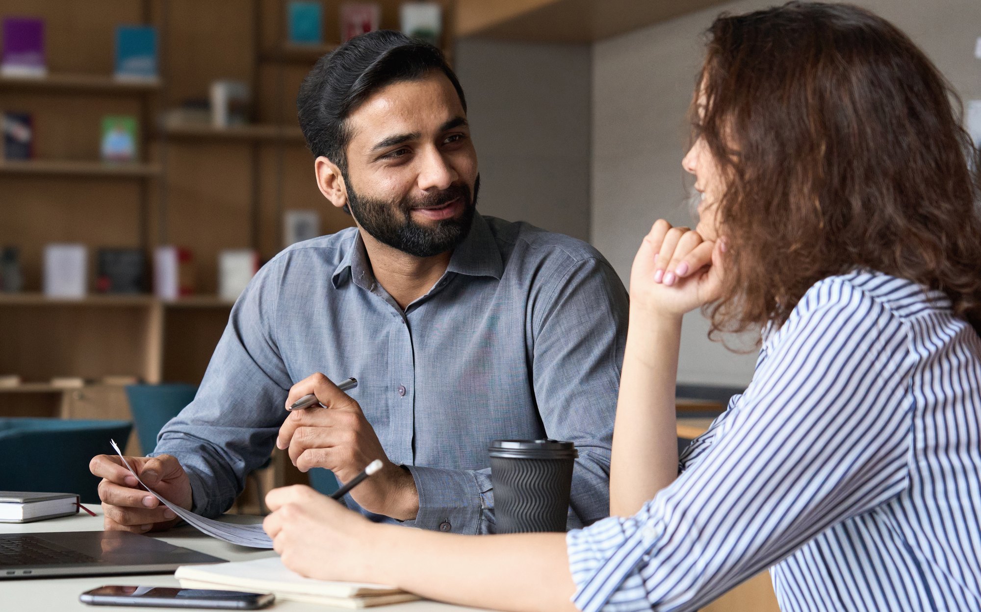 Two people in conversation across a desk